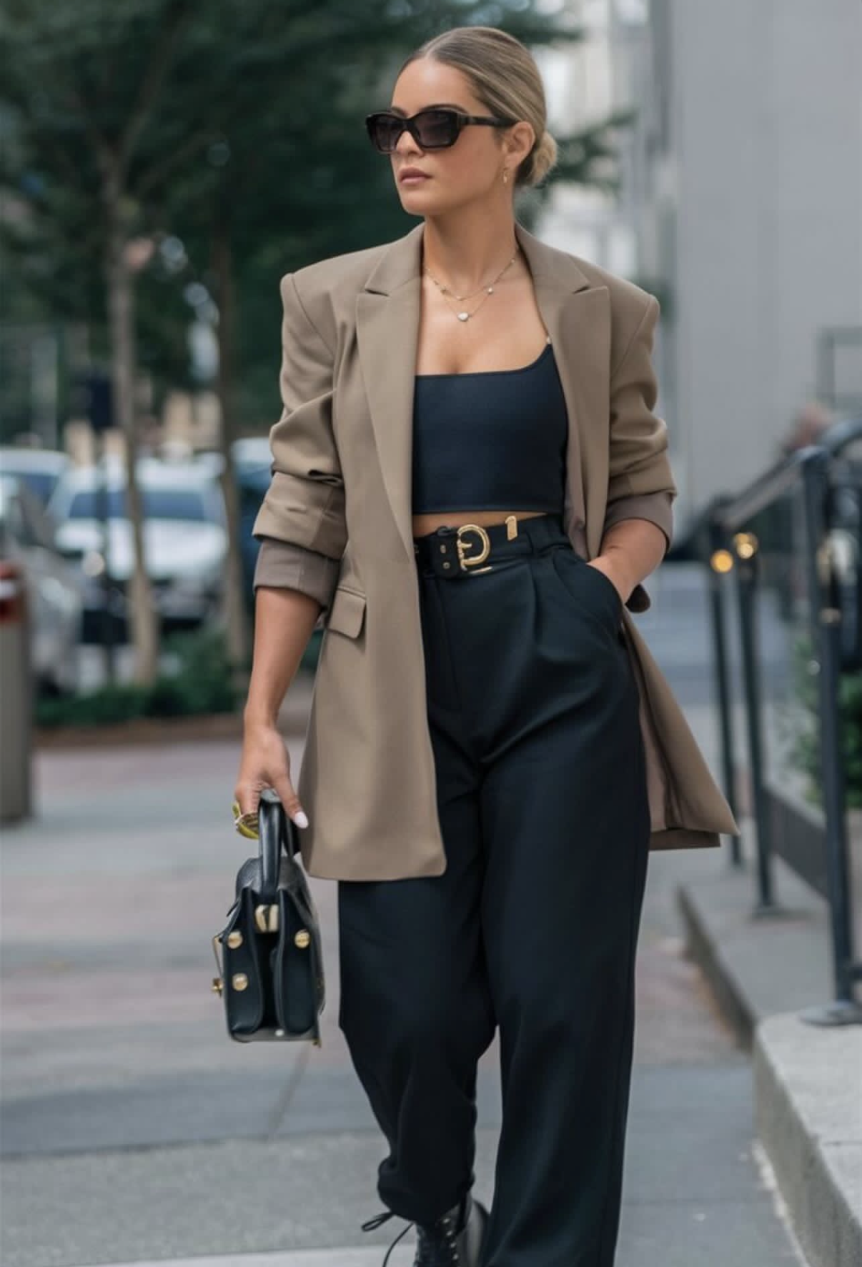 Femme en blazer beige, top noir et pantalon noir, lunettes de soleil noires